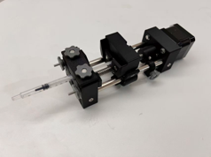 Close-up photograph of a compact motor-driven linear translation mechanism